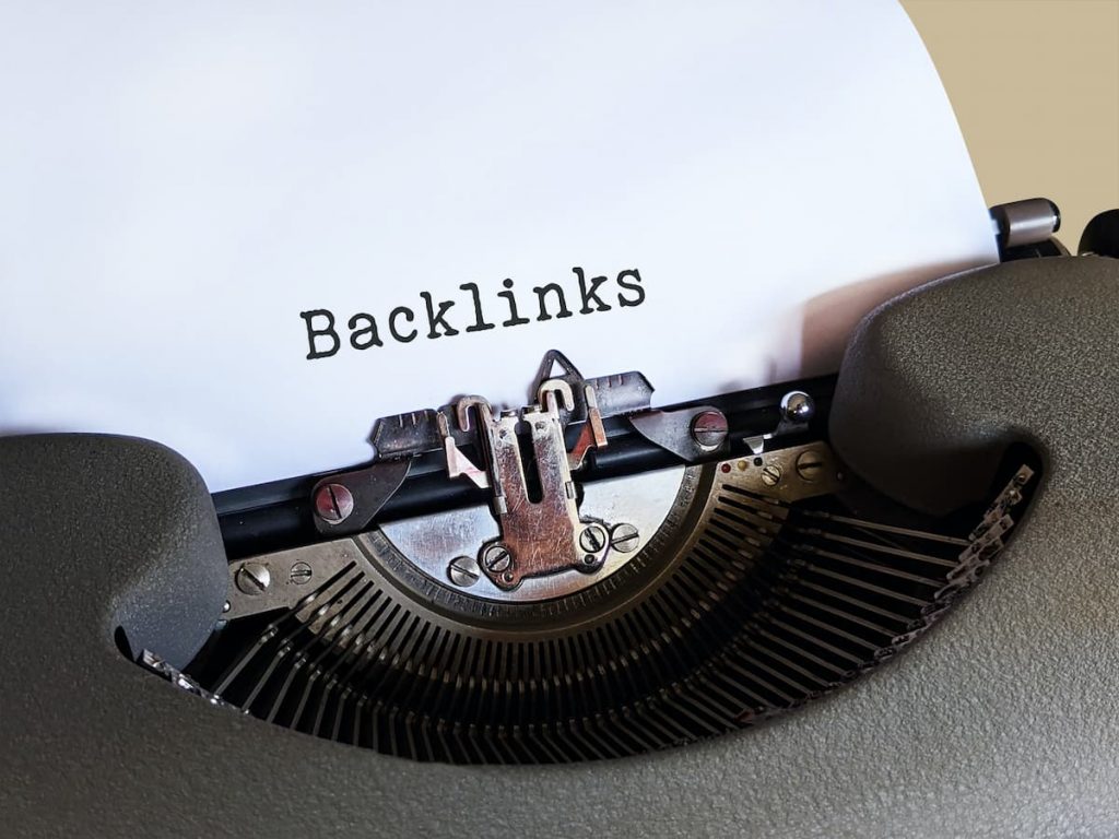 Une machine à écrire ancienne sur laquelle le mot backlinks est affiché, un terme utilisé en SEO local.